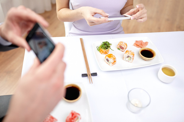 close up of couple with smartphones at restaurant - Photo, Image