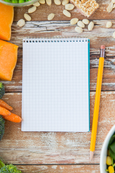 close up of ripe vegetables and notebook on table - Foto, Imagem