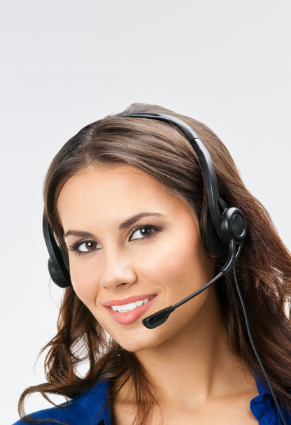 smiling young support phone operator, with copyspace, on grey   - 写真・画像