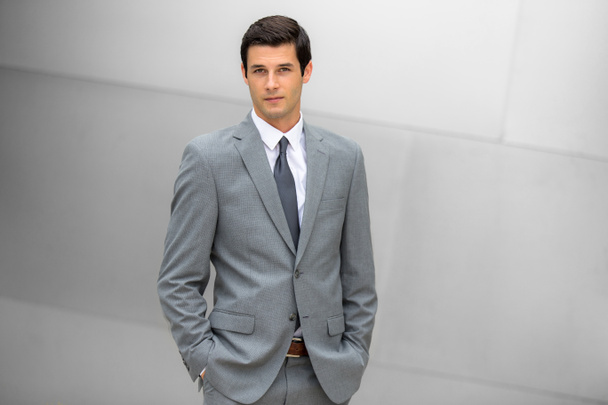gut aussehende männliche Finanzmanager Porträt steht selbstbewusst und in einem modernen Stil gekleidet - Foto, Bild