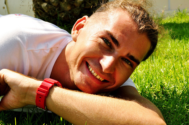 Smiling young man on the grass - Φωτογραφία, εικόνα