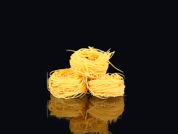  raw dry nest pasta with reflection  on black - Photo, Image