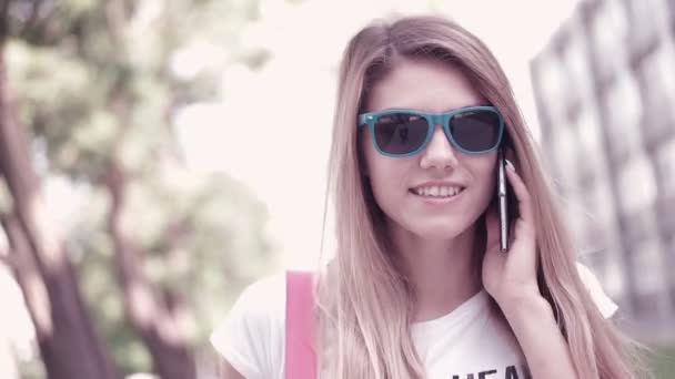 Atraktivní šťastný studentka mluví přes mobilní telefon - Záběry, video