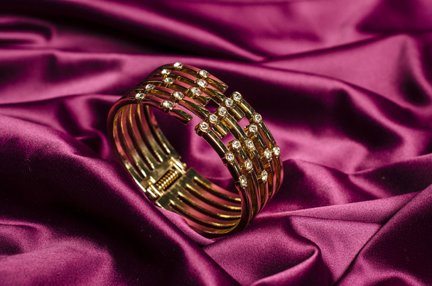 Goldarmband mit Diamanten auf roter Seide - Foto, Bild