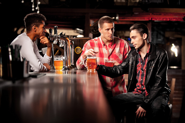 friends drink beer and spend time together in a bar. - Foto, Imagen