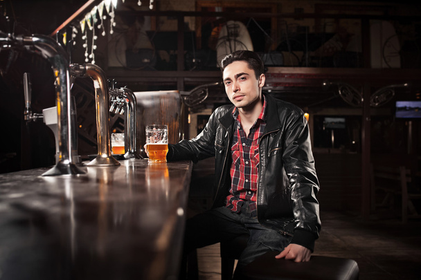 was a hard day. Depressed  man drinking beer in bar  - Foto, Bild