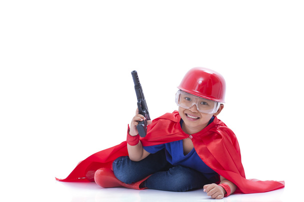 Child pretending to be a superhero with toy gun on white background - Foto, imagen