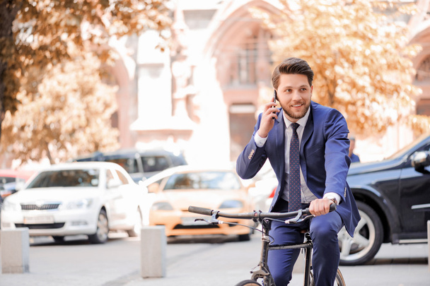 Handsome businessman riding his bicycle  - Φωτογραφία, εικόνα
