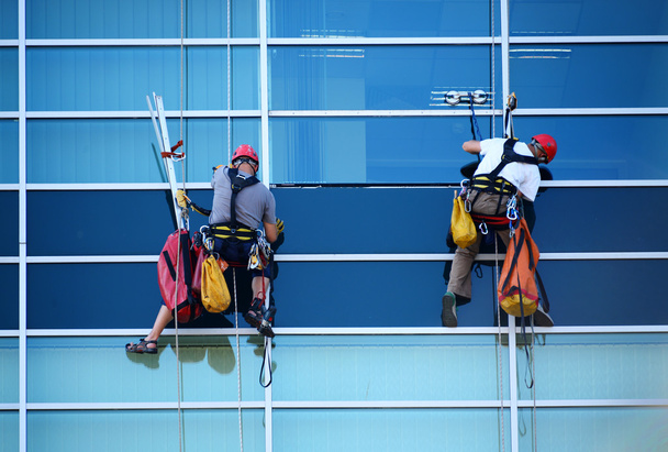 Zwei Bauarbeiter arbeiten in luftiger Höhe an Wolkenkratzer  - Foto, Bild