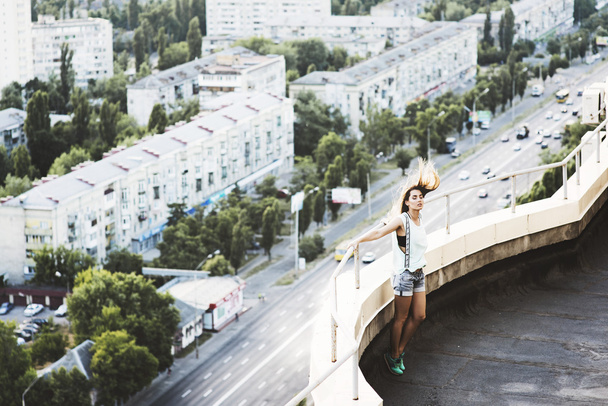 Young woman standing on the roof - Φωτογραφία, εικόνα