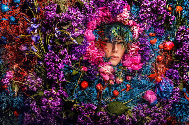 Fairy tale girl portrait surrounded with natural plants and flowers. Art image in bright fantasy stylization. - Foto, immagini