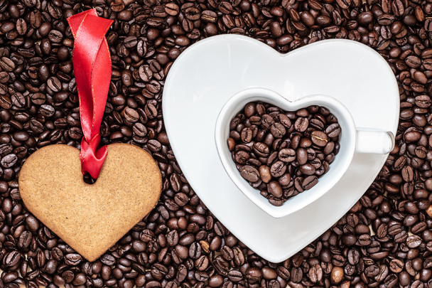 Heart shaped cup and cookie on coffee beans background - Photo, Image