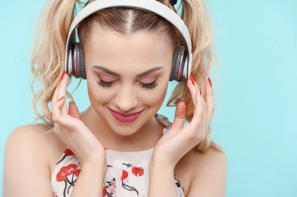 Beautiful blond young girl with big headphones - Foto, afbeelding