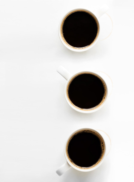 Tres tazas de café sobre fondo de papel
 - Foto, imagen