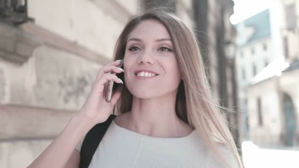 boldog asszony gyaloglás és beszélő keresztül mozgatható telefon-ban a város - Felvétel, videó