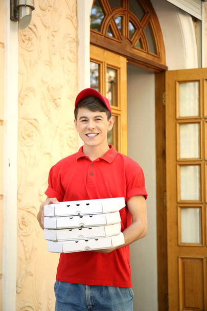 Young man delivering pizza box near house - Foto, Bild