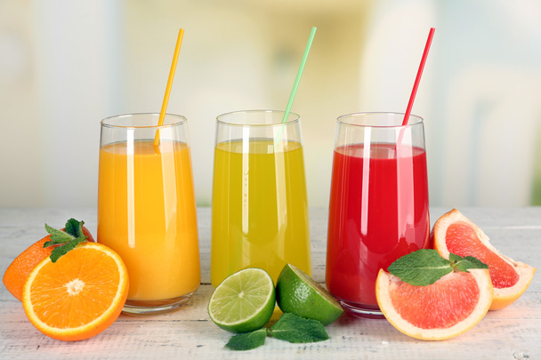 Bicchieri di diverso succo con frutta e menta su sfondo brillante
 - Foto, immagini