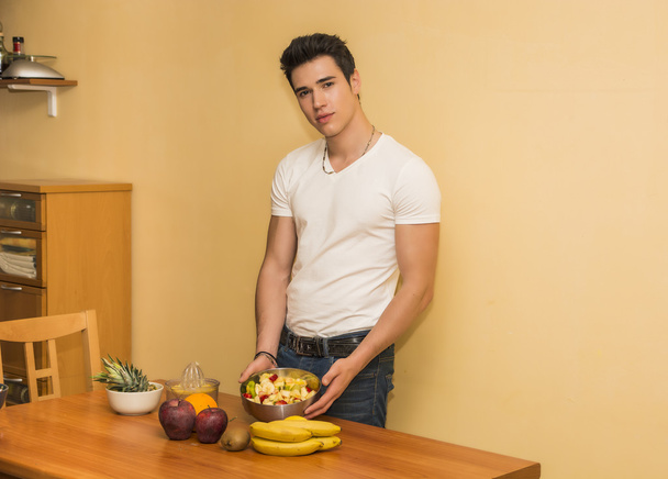 Young man preparing a fruit salad or smoothie - Фото, изображение
