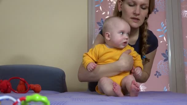 χαμογελαστή γυναίκα διδάσκει το μωρό να καθίσει μόνη της. 4K - Πλάνα, βίντεο