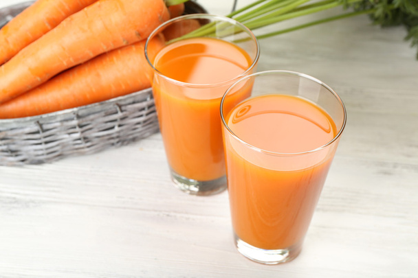 Glasses of carrot juice with vegetables on table close up - Photo, image