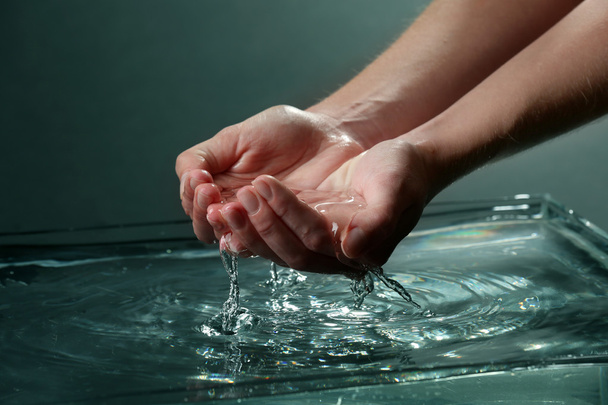 Female hands with water splashing on dark background - Photo, Image