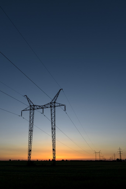 grote transmissie torens bij zonsondergang - Foto, afbeelding