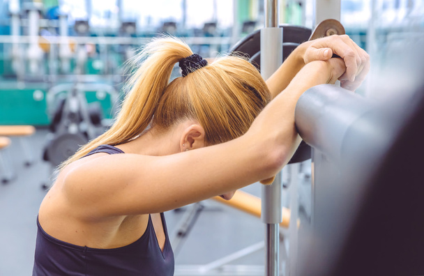 Mujer descansando cansado después de levantar la barra en el entrenamiento muscular
 - Foto, Imagen