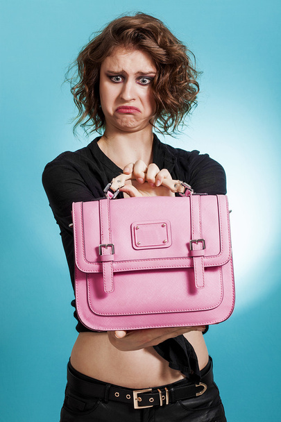 Beautiful girl holding a pink bag with disgusted look - Foto, immagini