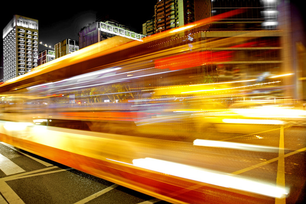 υψηλής ταχύτητας και το φως μονοπάτια θολή λεωφορείων στο κέντρο της πόλης nightscape - Φωτογραφία, εικόνα