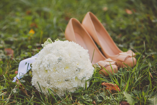 Zapatos de boda y ramo de novia de flores blancas al aire libre
 - Foto, imagen