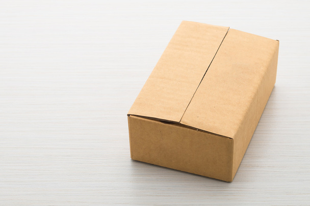 Бумажная коробка на деревянном фоне
 - Фото, изображение