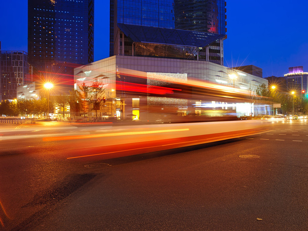 vysoká rychlost a rozmazané autobus světlé stezky v centru noční krajinou - Fotografie, Obrázek