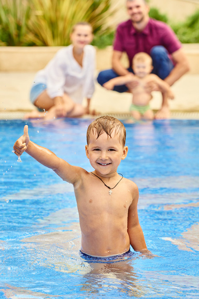 Kleiner Junge mit seiner Familie im Schwimmbad - Foto, Bild