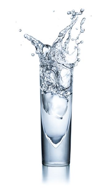 Glas mit klarer Flüssigkeit mit Eiswürfel und Spritzer - Foto, Bild