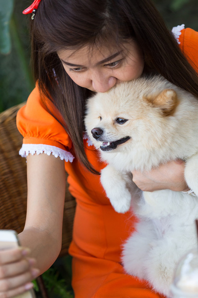 mulheres usando selfie telefone móvel com cão pomerano animais de estimação bonitos
 - Foto, Imagem