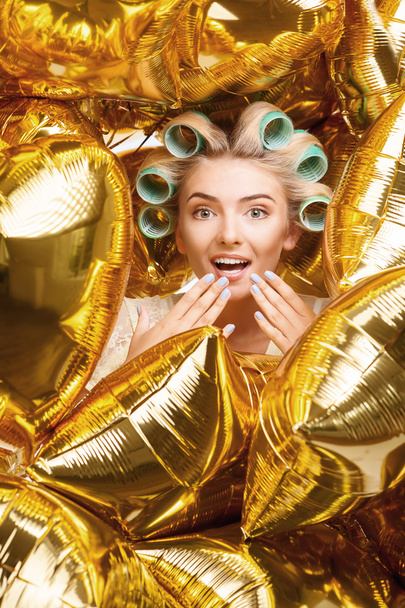 Beautiful young woman with curlers is celebrating - Фото, изображение
