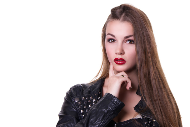 Beautiful girl with a red lipstick dressed in a black leather jacket. Isolated over white background.  Copy space. - Photo, Image