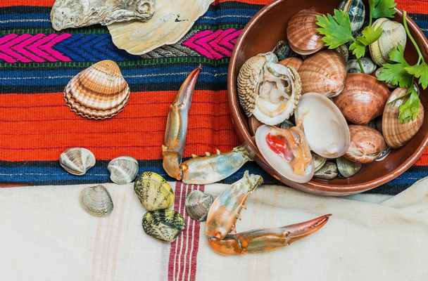 Frutti di mare con artigli di granchio e conchiglie disposte su tessuto Etnico
. - Foto, immagini