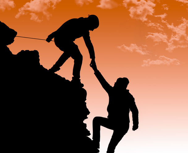 silhouet van helpende hand tussen twee klimmer - Foto, afbeelding
