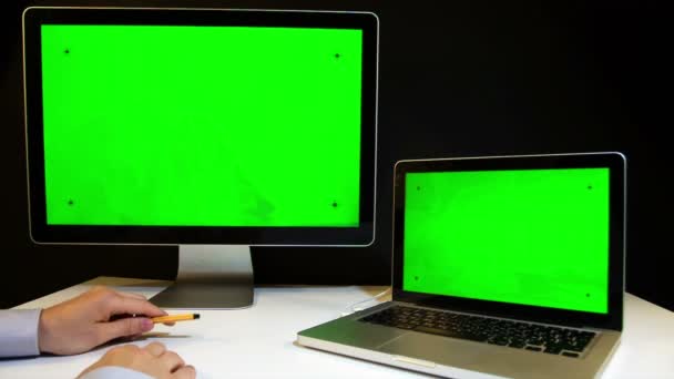 Man Working on the Laptop and Display with a Green Screen - Materiał filmowy, wideo