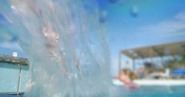 Ευτυχισμένο παιδί στην πισίνα που πιτσιλίζει το νερό - Πλάνα, βίντεο