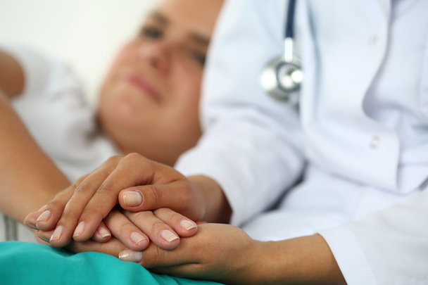 Ystävällinen naislääkäri kädet pitämällä potilaan käsi
 - Valokuva, kuva