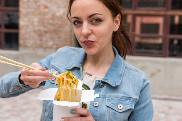 Woman Eating Take Out Noodles with Chopsticks - Fotó, kép