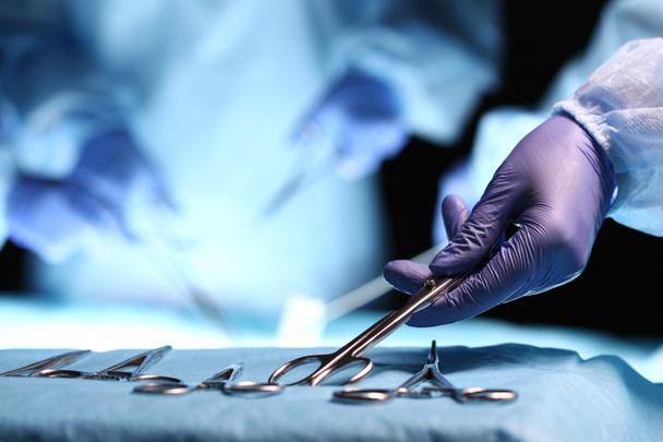 Рука медсестри приймає хірургічний інструмент
  - Фото, зображення