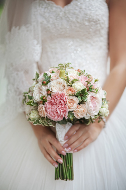 roses in hands of the bride. Focus on flowers - Фото, изображение