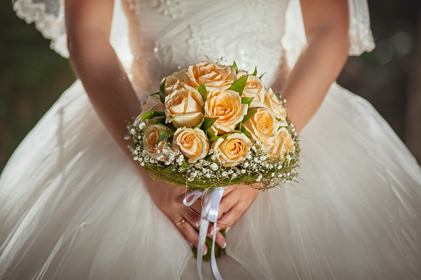 Orange roses in hands of the bride - Фото, изображение