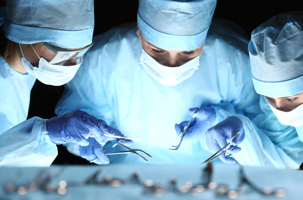 Groupe de chirurgiens au travail opérant en salle d'opération
 - Photo, image
