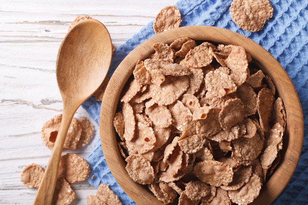 cereal flakes in a wooden bowl closeup. Horizontal top view - Photo, Image
