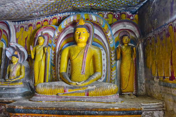Картины на стене и статуи Будды в Золотом Храме Пещеры Дамбулла
 - Фото, изображение