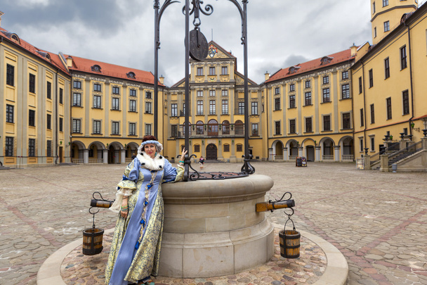 ネスヴィジ城の領土に中世のドレスを着た女性。ベラルーシ. - 写真・画像